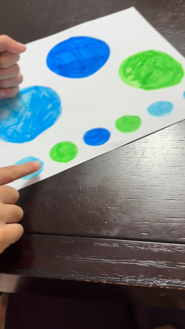 A child forming a letter with playdoh on a Learn with Sean card